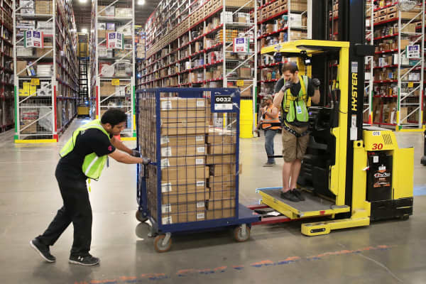 Workers pack and ship customer orders at the 750,000-square-foot Amazon fulfillment center in Romeoville, Illinois.