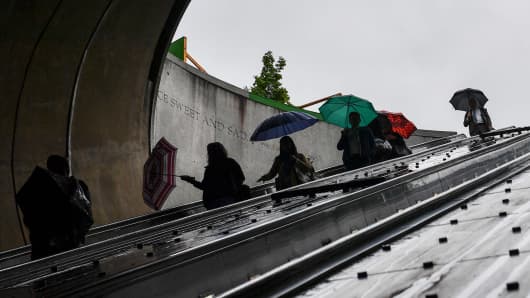 Metro commuters use the escalator at the Dupont Circle Metro station during a light rain in Washington, D.C.
