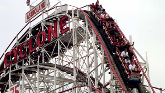 Visitors to Coney Island enjoy a thrill ride on the world famous 'Cyclone' rollercoaster