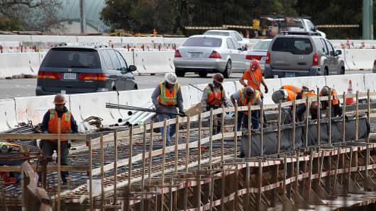 Construction crews work on a freeway overpass along Highway 101 in Novato, California.