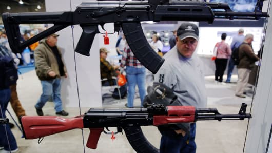 A man walks past a gun display at a National Rifle Association outdoor sports trade show on February 10, 2017 in Harrisburg, Pennsylvania.