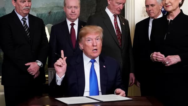 President Donald Trump, surrounded by business leaders and administration officials, prepares to sign a memorandum on intellectual property tariffs on high-tech goods from China, at the White House in Washington, U.S. March 22, 2018.