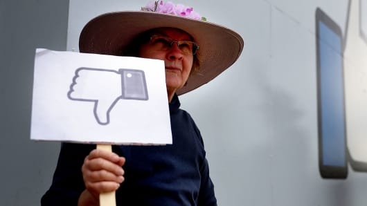 A protester with the group 'Raging Grannies' holds a sign during a demonstration outside of Facebook headquarters on April 5, 2018 in Menlo Park, California.