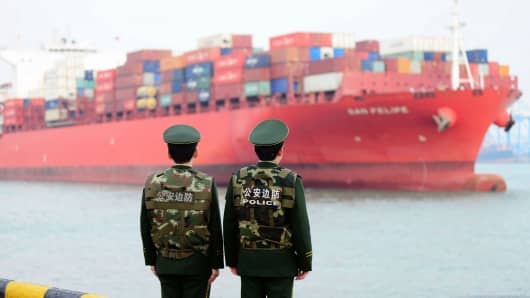 Soldiers wait for a container ship to berth at Qingdao Port on March 8, 2018 in Qingdao, China.