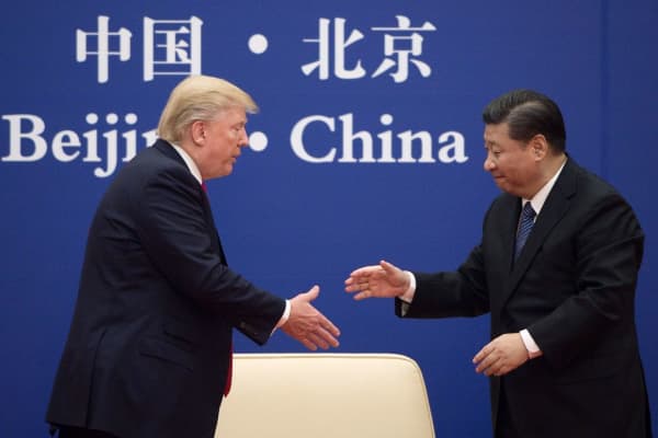 China's President Xi Jinping shakes hands with U.S. President Donald Trump (L) during a business leaders event at the Great Hall of the People in Beijing on Nov. 9, 2017.