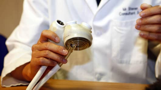 A doctor holds a SynCardia Total Artificial Heart.
