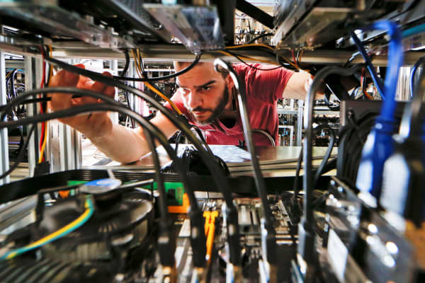 An employee works on bitcoin mining computers at Bitminer factory in Florence, Italy.