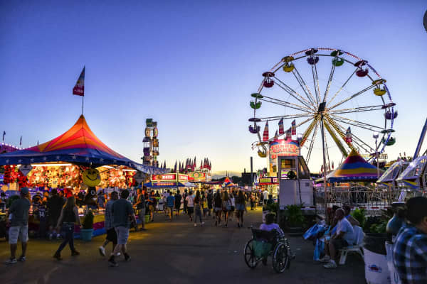 Minnesota State Fair Midway Farris Wheel and game stands at dusk. Located in St. Paul, Minnesota.