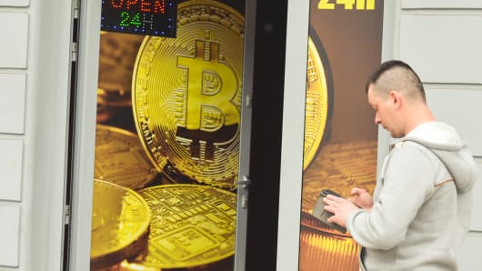 A man passes in front of a Bitcoin exchange shop.