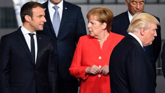French President Emmanuel Macron (L) and German Chancellor Angela Merkel (2nd L) speaks as US President Donald Trump (C) arrives for a family picture during the NATO (North Atlantic Treaty Organization) summit at the NATO headquarters, in Brussels, on May 25, 2017.