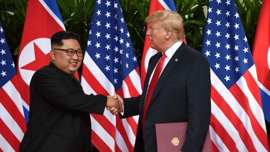 U.S. President Donald Trump and North Korea's leader Kim Jong Un shake hands during their summit at the Capella Hotel on Sentosa island in Singapore June 12, 2018.