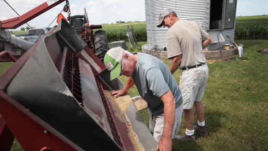 Farmer John Duffy (L) and Roger Murphy load soybeans from a grain bin onto a truck before taking them to a grain elevator on June 13, 2018 in Dwight, Illinois. U.S. soybean futures plunged with renewed fears that China could hit U.S. soybeans with retaliatory tariffs if the Trump administration follows through with threatened tariffs on Chinese goods.
