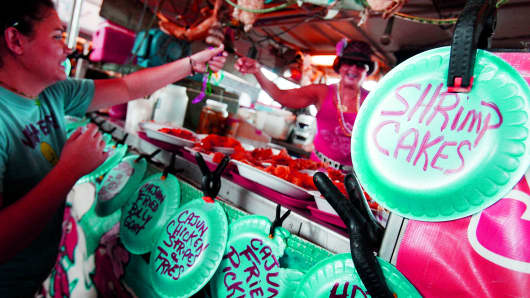 Jane Fontenot of Fontenot's Cajun Seafood passes out Mardi Gras beeds to customers for there support during the 75th Annual Shrimp and Petroleum Festival in Morgan City, Louisiana.