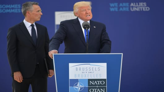 US President Donald Trump (C) delivers a speech next to NATO Secretary General Jens Stoltenberg (L) during the unveiling ceremony of the Berlin Wall monument, during the NATO (North Atlantic Treaty Organization) summit at the NATO headquarters, in Brussels, on May 25, 2017.