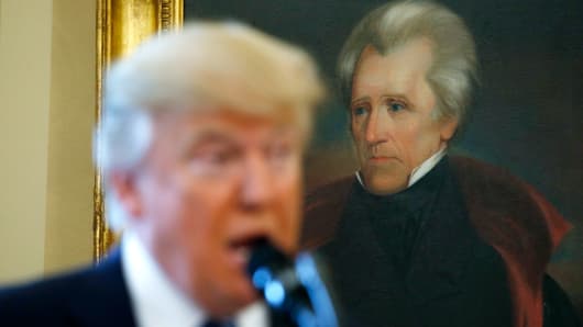 President Donald Trump speaks in front of a portrait of former U.S. President Andrew Jackson in the Oval Office.  