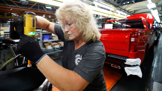 Kathy Huff installs a headlight assembly at GM's Chevrolet Silverado and GMC Sierra pickup truck plant in Fort Wayne, Indiana, July 25, 2018. 