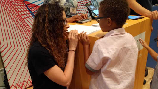 Allen talks to a visually impaired boy at Google's booth at a National Federation of the Blind conference.