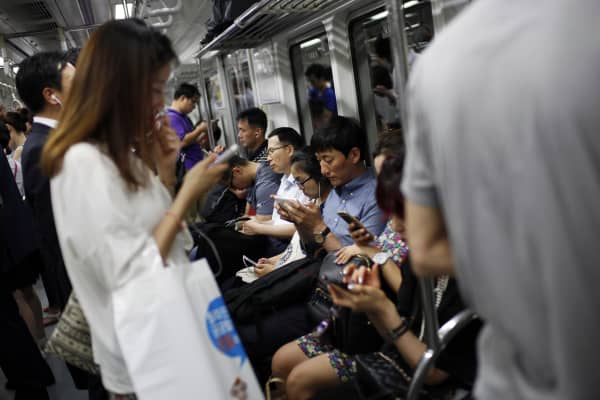 Passengers use smartphones inside a subway train in Seoul, South Korea, in 2015.  