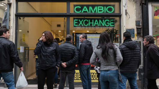 People wait outside of a currency exchange house in Buenos Aires, Argentina, on Thursday, Aug. 30, 2018. 