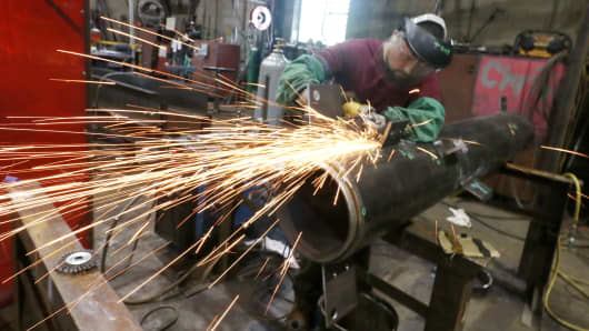 A man using an angle grinder on a steel piece at a metal fabrication company on August 7, 2018 in Orange County, New York.