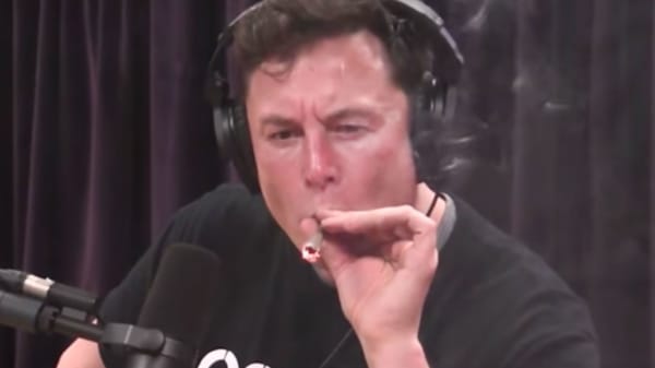Elon Musk smokes marijuana with Joe Rogan during a taping of Rogan's podcast show. 