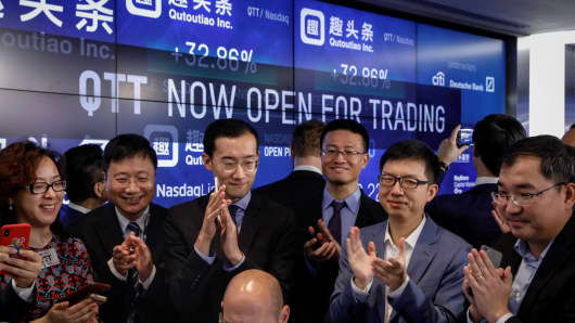 Eric Siliang Tan, (2nd-R) Chairman and CEO of Qutoutiao Inc., celebrates his company's IPO as it begins trading at the Nasdaq MarketSite in New York City, U.S., September 14, 2018.Â 