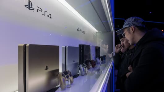 Attendees look at Sony Corp. PlayStation 4 (PS4) game consoles on display during the 2018 Taipei Game Show in Taipei, Taiwan, on Friday, Jan. 26, 2018.Â 