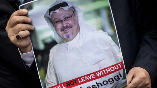 A man holds a poster of Saudi journalist Jamal Khashoggi during a protest organized by members of the Turkish-Arabic Media Association at the entrance to Saudi Arabia's consulate on October 8, 2018 in Istanbul, Turkey. 