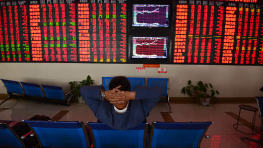 An investor watches the electronic board at a stock exchange hall on October 19, 2018 in Fuyang, Anhui Province of China. 