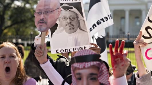 Demonstrators hold photographs of journalist Jamal Khashoggi outside the White House in Washington, D.C., on Friday, Oct. 19, 2018.