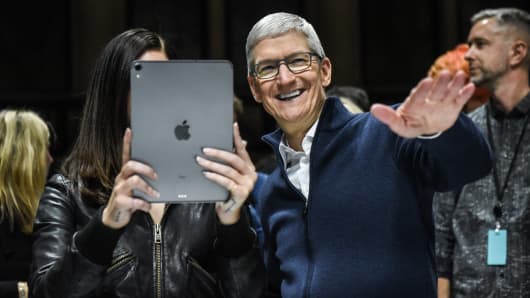 Tim Cook, CEO of Apple laughs while Lana Del Rey (with iPad) takes a photo during a launch event at the Brooklyn Academy of Music on October 30, 2018 in New York City. 