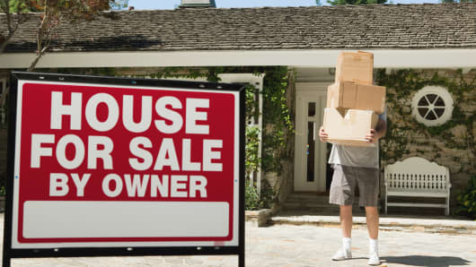Mature man carrying boxes to move into newly bought property
