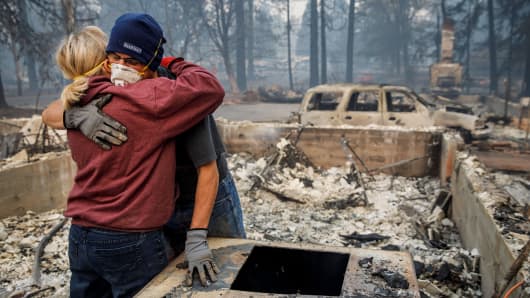 Michael John Ramirez hugs his wife Charlie Ramirez after they recover her keepsake bracelet which held a sentimental value as they recover items from the rubble of their destroyed home, after the Camp fire in Paradise, Calif., on Nov. 15, 2018. 