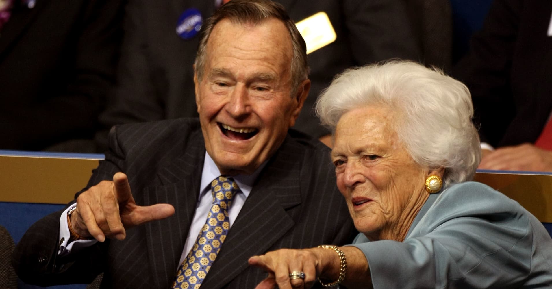 Former President George H.W. Bush (L) and former first lady Barbara Bush (C) point from their seats on day two of the Republican National Convention (RNC) at the Xcel Energy Center on September 2, 2008 in St. Paul, Minnesota. 