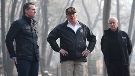 US President Donald Trump (C) looks on with Governor of California Jerry Brown (R) and Lieutenant Governor of California, Gavin Newsom, as they view damage from wildfires in Paradise, California on November 17, 2018.