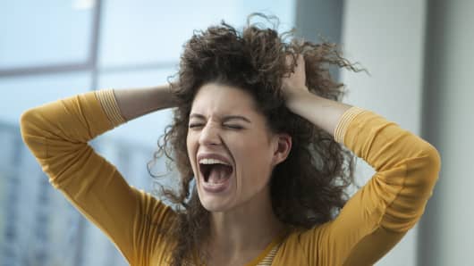 Screaming young woman with hands in hair