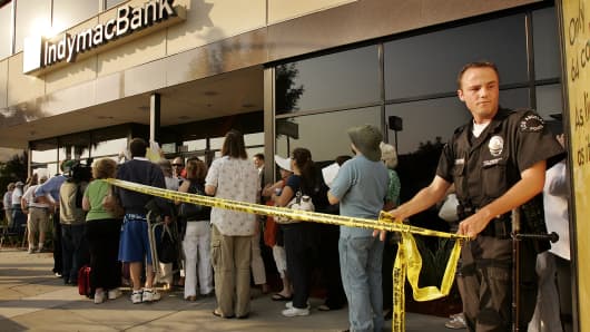 A Los Angeles Police Officer uses yellow tape to cordon off an area for customers with names on a list waiting to enter the IndyMac Federal Bank branch in Encino in July, 2008.