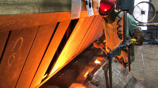 A worker pours molten iron into molds to form parts for Caterpillar Inc. and other industrial customers at Kirsh Foundry Inc. in Beaver Dam, Wisconsin.
