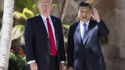Chinese President Xi Jinping (R) waves to the press as he walks with US President Donald Trump at the Mar-a-Lago estate in West Palm Beach, Florida, April 7, 2017.
