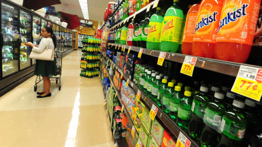A woman shops for frozen foods on an aisle across from sodas and other sugary drinks at a superrmarket in Monterey Park, California.