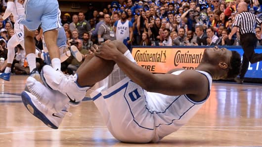 Duke forward Zion Williamson holds his knee after injuring himself and damaging his shoe during the opening moments of the game in the first half on Wednesday, Feb. 20, 2019, at Cameron Indoor Stadium in Durham, N.C.