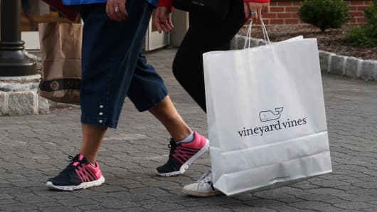 A woman walks with a bag from the Vineyard Vines store at the Woodbury Common Premium Outlets in Central Valley, New York State.