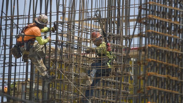 Construction workers are seen as they work with steel rebar during the construction of a building on May 17, 2019 in Miami, Florida.